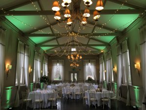 morden hall decorated with fairy lights, white cloth tables and chairs