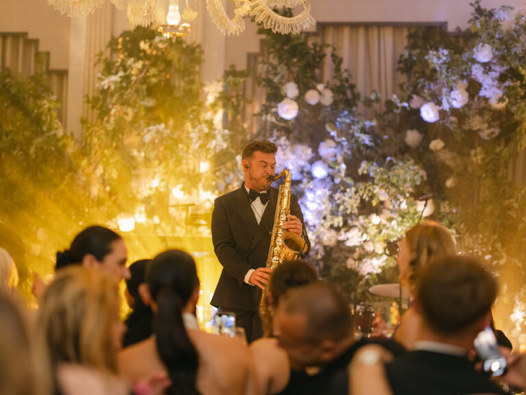 Saxophonist backlit by moving head lights